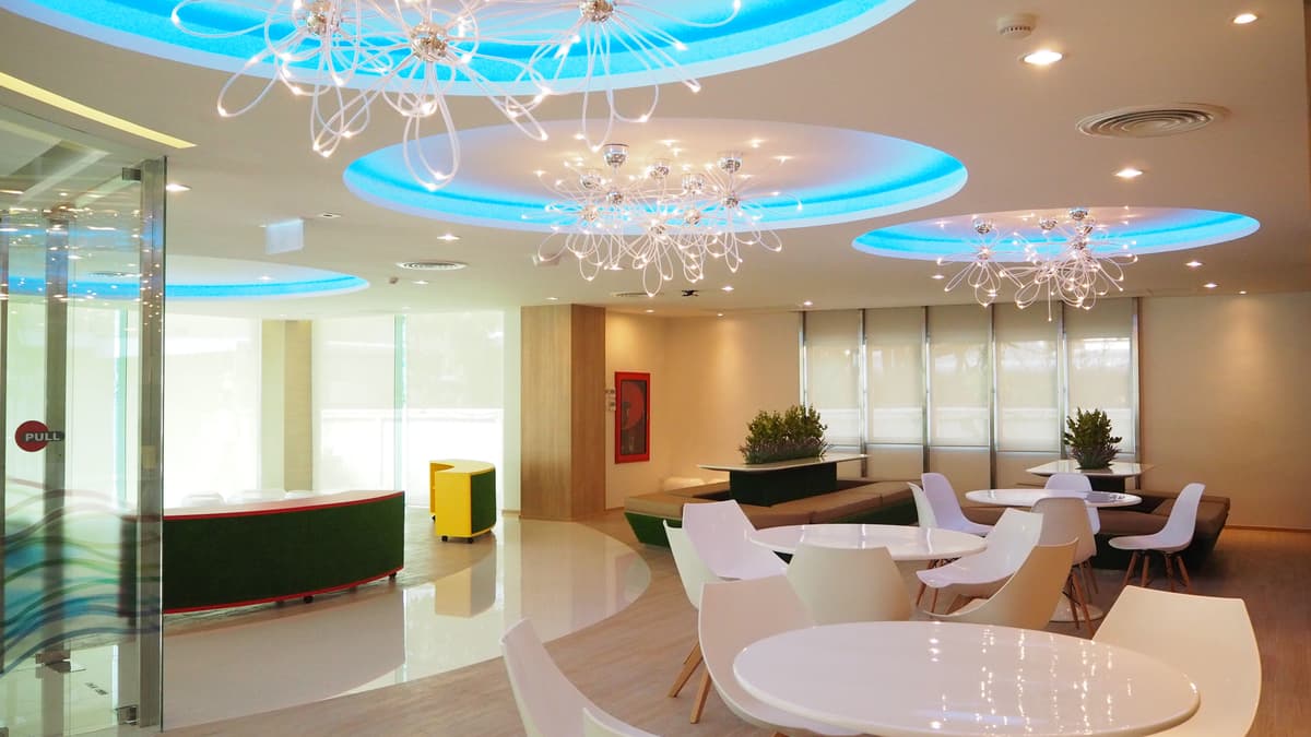 พื้นที่พักผ่อนภายในออฟฟิศ CPF ตกแต่งด้วยโต๊ะกลมและไฟเพดานสีฟ้า