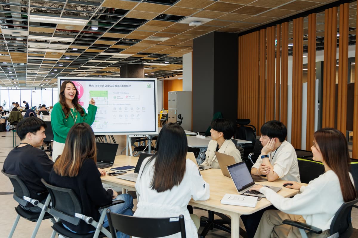 พนักงาน AIS นำเสนอข้อมูลให้ทีมงานฟังในออฟฟิศ